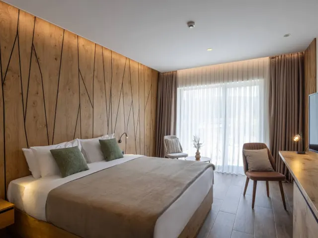 Helles Doppelzimmer in der Alpensaline mit Holzwand, Doppelbett und großem Fenster