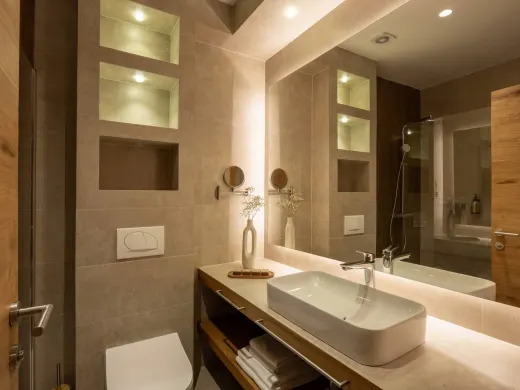 Modernes Badezimmer mit beleuchtetem Spiegel und Waschtisch