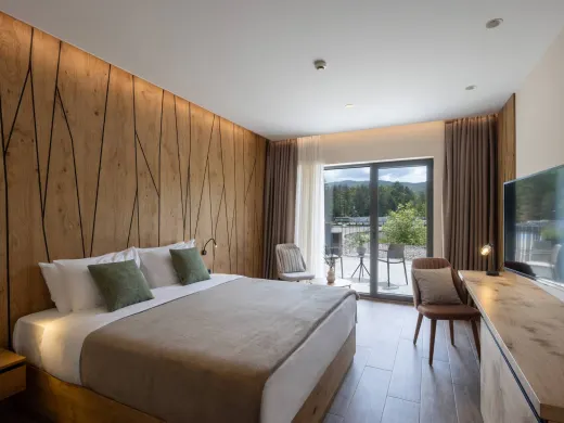 Doppelzimmer mit Bett, Sitzecke und Zugang zum Außenbereich