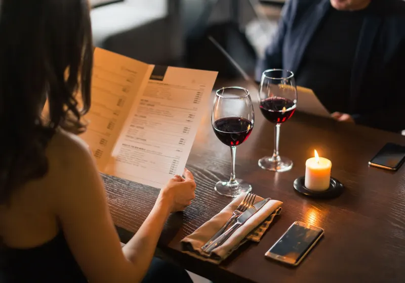 Gäste studieren die Speisekarte bei Rotwein und Kerzenlicht im Restaurant SIEBZEHN